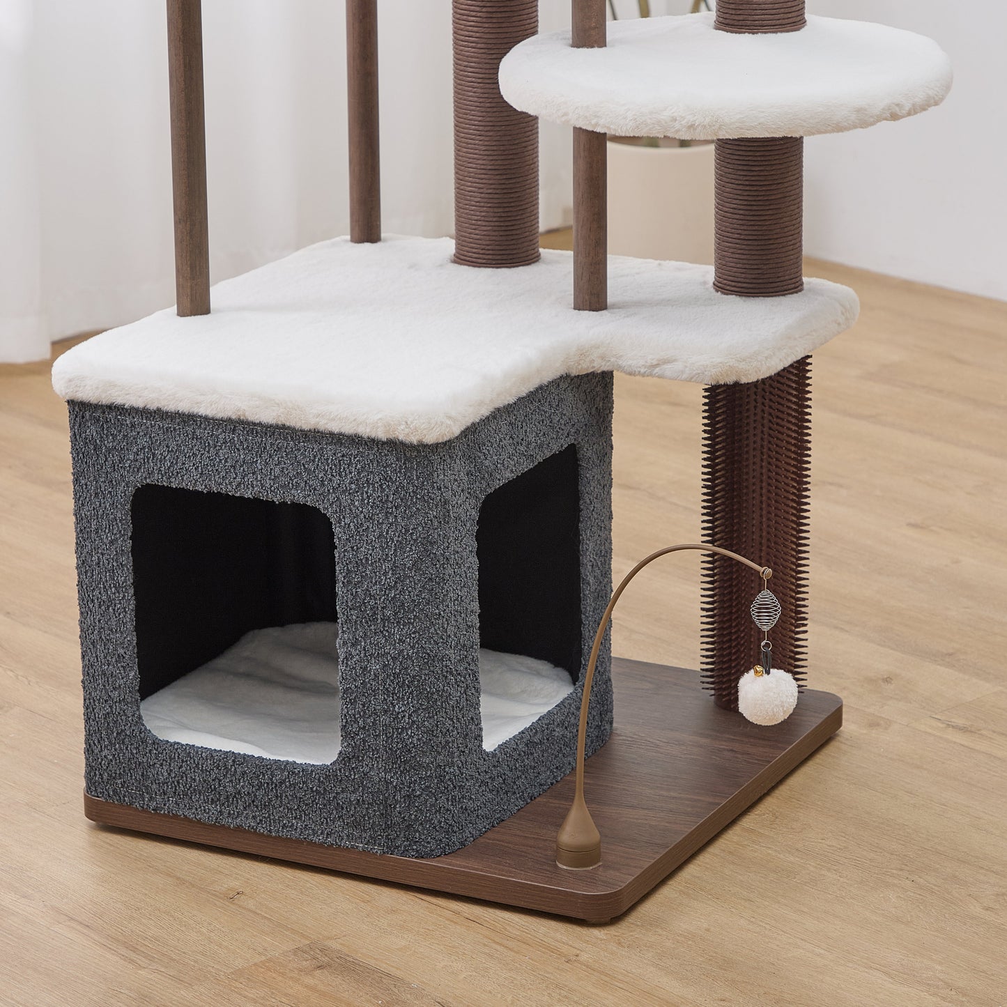 Catry Trinity CT240359 cat tree
with a cat condo, rubber groomer, multiple levels and a swivel hanging cat toy on a wooden floor.